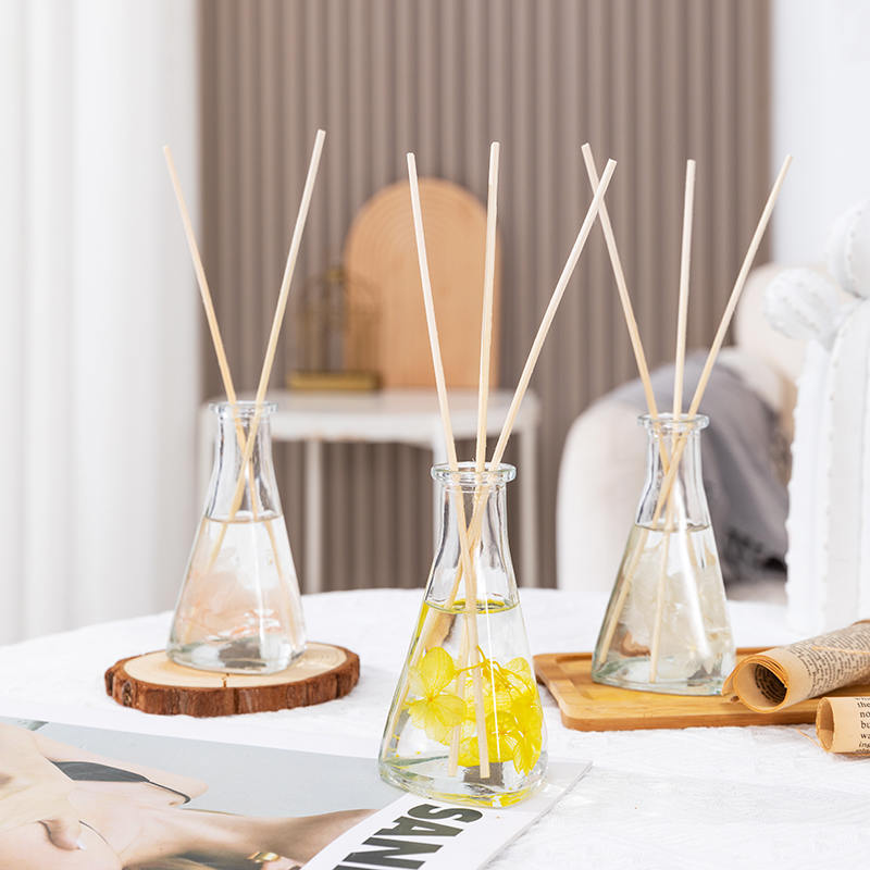 ขวดรูปสามเหลี่ยมดอกไม้แห้งเถาวัลย์ไม่มีไฟกระจายกกอโรมาในร่ม ขวดรูปสามเหลี่ยมดอกไม้แห้งเถาวัลย์ไม่มีไฟกระจายกกอโรมาในร่ม